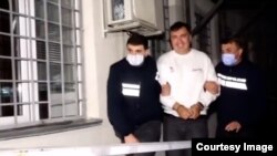 Video footage released by the Georgian Interior Ministry on October 1 showed a handcuffed Mikheil Saakashvili being escorted by police into an unidentified building. 