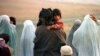 Afghanistan -- Afghan refugees walk along the road fleeing fighting north of Kabul October 11